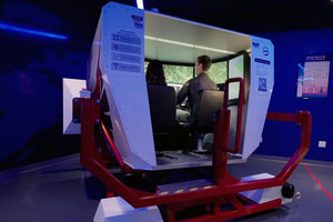 two people sit in a flight simulator in a large room