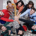 group of people in a circle with hands in the middle