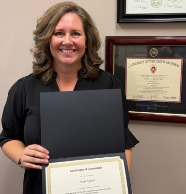 woman standing in front of diplomas