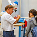 Researcher explaining technology to woman listening