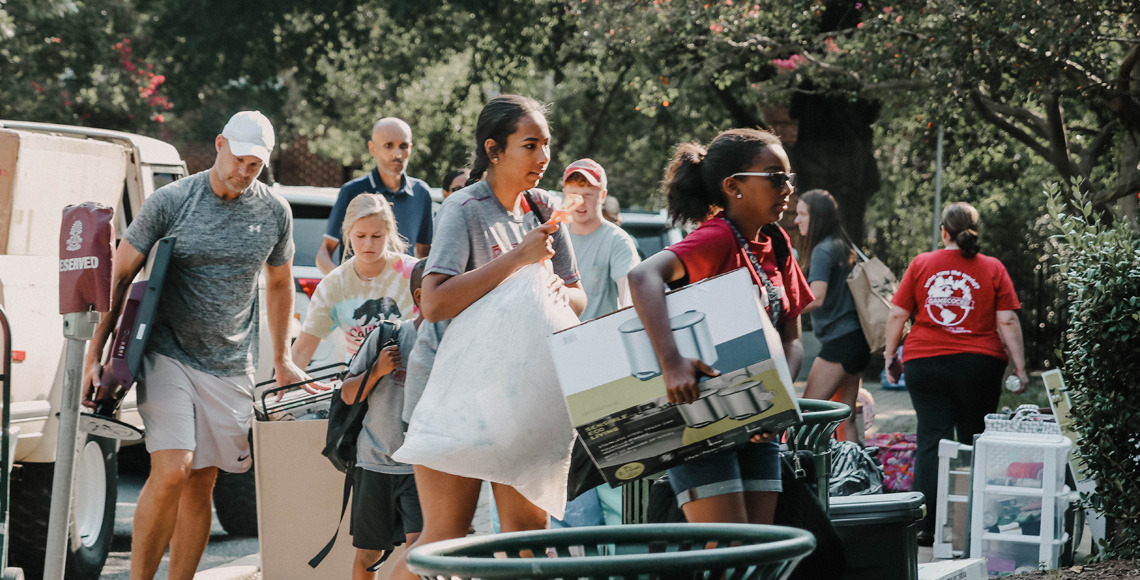 Two students moving packages into Capstone on move in day.