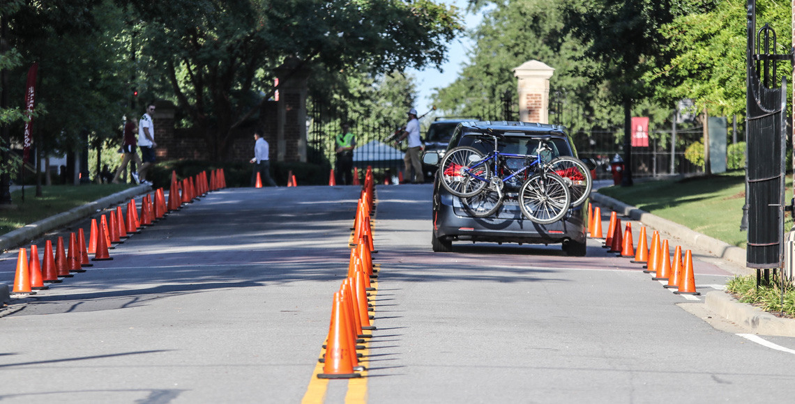 Mini van driving up Greene Street with bikes on the back on move in day.