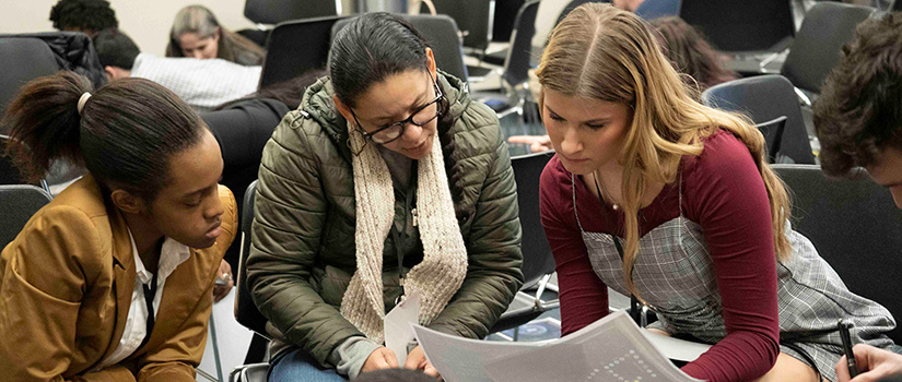 Students read a piece of paper at a Diversity Matters event.