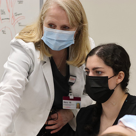 Student and teacher looking at a sonograp machine