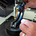 man with microscope and bullet