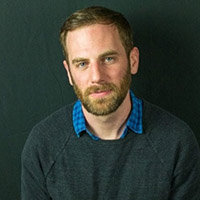 photo of man in blue shirt and green sweater