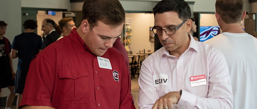 Dr. Caicedo looks at papers with a student