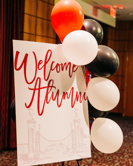 Honors alumni sign decorated with balloons