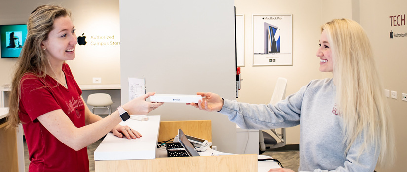 A cashier at the Gamecock iHub hands a customer a product after checking out.