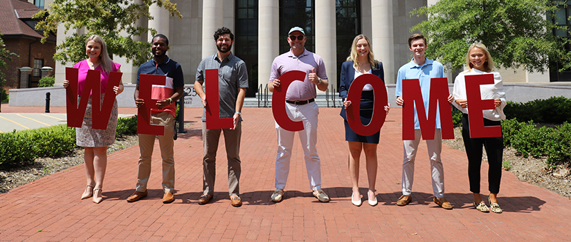 Students holding welcome sign in front of USC School of Law building