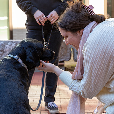 Student playing with puppy in Courtyard