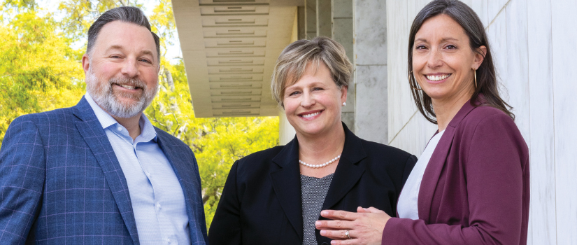 Three alumni standing outside