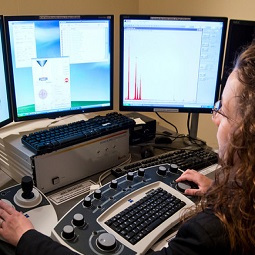 Woman looking at 3 computer screens