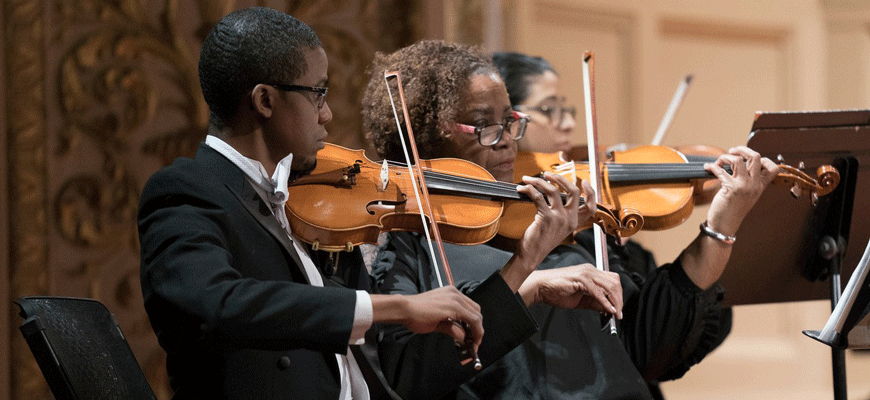 three musicians play violins on state