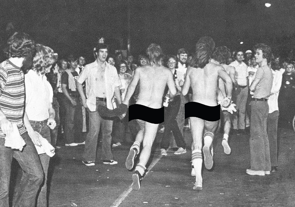 archival image of two men streaking through a crowd